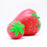 Two red strawberry squishies laying on their sides with green leaves on top. One is bigger than the other
