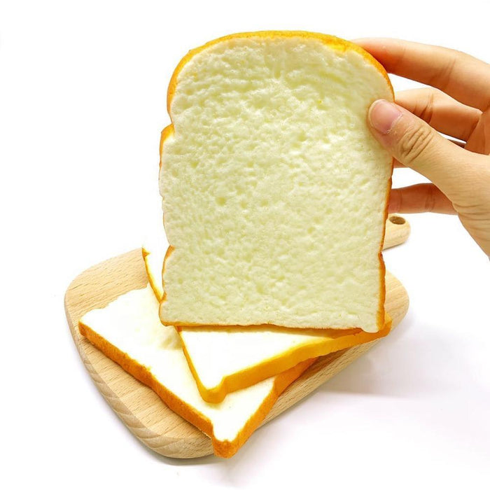 A hand holding a squishy that looks like a slice of white bread 