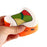 A hand squishing an orange and white squishy that resembles sushi with a green and red square on its top