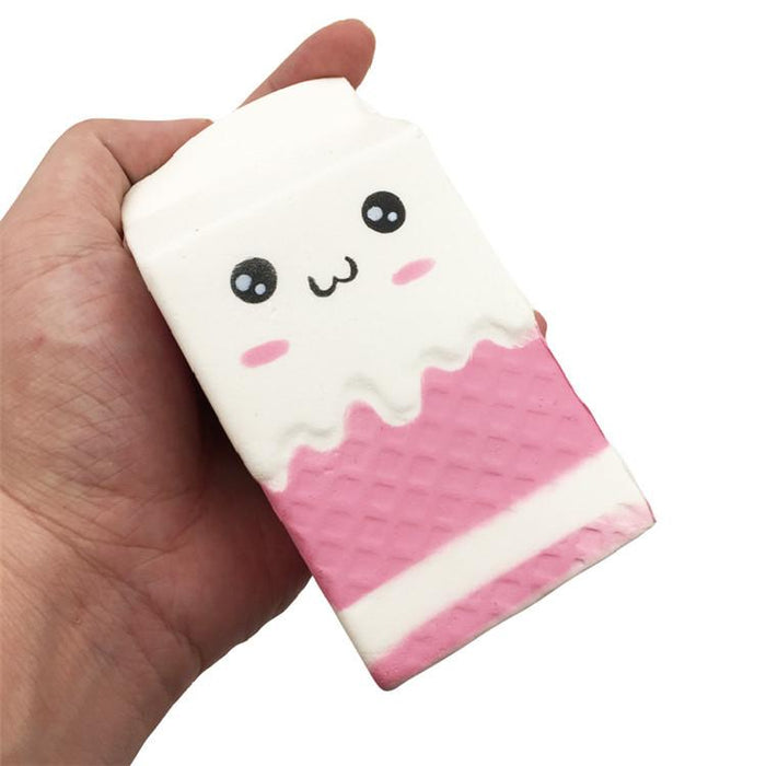 A hand holding a white and pink milk carton with round black eyes and pink cheeks