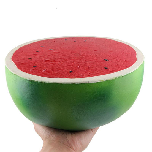 A hand holding a half sphere squishy that looks like a watermelon sliced by the middle. 