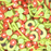 A mix of long and round green sprinkles with red tomato slices and avocado slices sprinkles