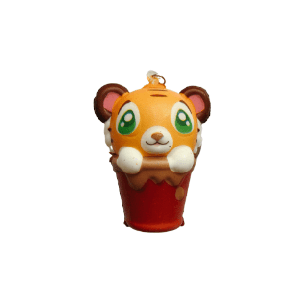 A squishy keychain with the shape of a tiger inside a red bucket with brown drips.