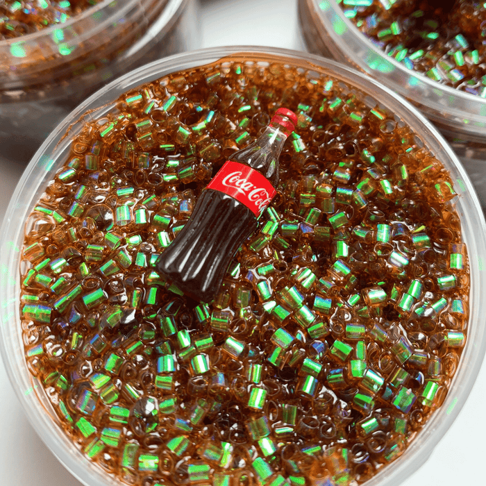 Brown bingsu slime with many brown iridescent sprinkles and a cola soda charm as decoration.
