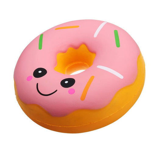 A round donut squishy with pink glazing, round eyes and a smile and multicoloured sprinkles