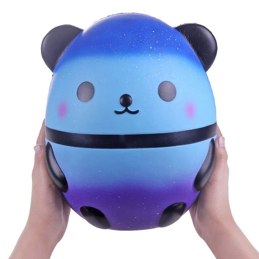 Two hands holding a gradient blue and purple panda squishy with white spots