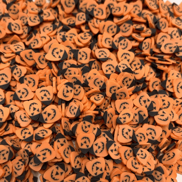 A mix of orange Halloween pumpkin sprinkles with black witches hats.